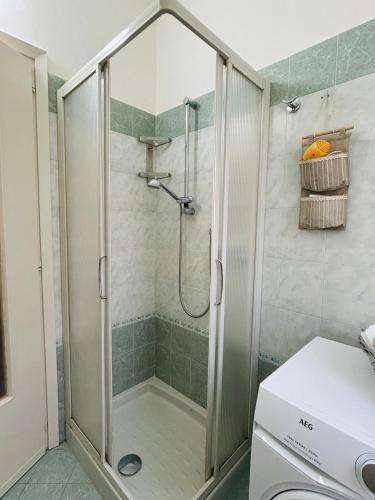 a shower with a glass door in a bathroom at Casa Flora in Biella