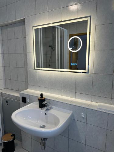 a white bathroom with a sink and a mirror at Bergblick Appartements in Bad Gastein