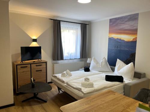 a bedroom with a bed and a television and a table at Bergblick Appartements in Bad Gastein