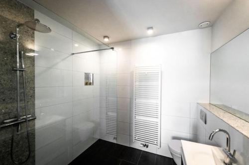 a white bathroom with a shower and a sink at Rue Haute by M&M 4 sterren bed en breakfast vlakbij Maastricht in Eben-Emael