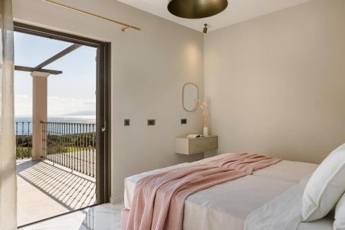 una camera da letto con un letto e un balcone di Villa Oro di Agathera Kefaloniaprivatevillas ad Argostoli