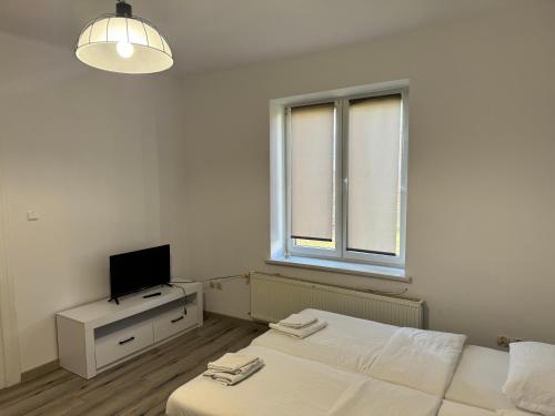 Habitación blanca con 2 camas y TV en Apartamenty 649 metrów od Dworca, en Przemyśl