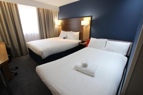 a hotel room with two beds with white sheets at Holiday Inn Express Nuneaton by IHG in Nuneaton