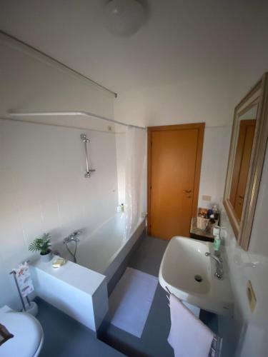 a bathroom with a tub and a sink and a toilet at Appartamento Hellas in Marotta