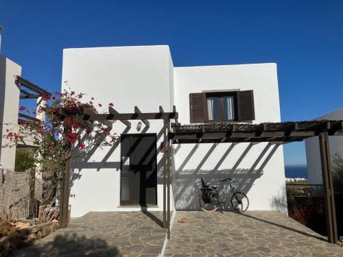 ein weißes Gebäude mit einem davor geparkten Fahrrad in der Unterkunft Casa Mar y Carmen in Las Negras