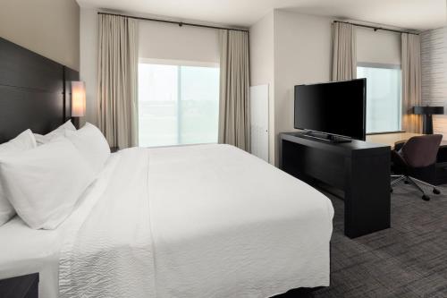 a hotel room with a bed and a flat screen tv at Residence Inn by Marriott East Peoria in Peoria