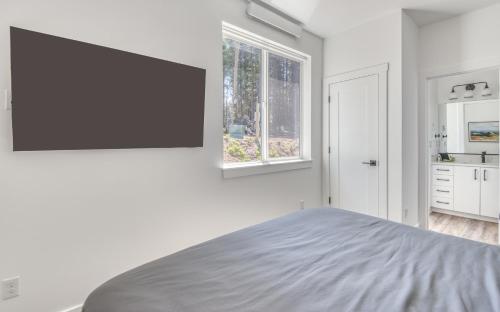 a white bedroom with a bed and a window at Harbor Lights 2 Family Fun Retreat Coastal Comfort in Depoe Bay