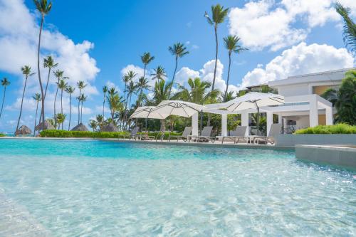 Xeliter Playa Coral, Bavaro في بونتا كانا: حمام سباحة في منتجع به أشجار النخيل