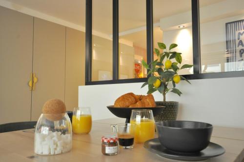 una mesa con un tazón de pan y zumo de naranja en MONACO # MENTON - 4 PERSONS - HYPERCENTER - BEACH AND SUN - PRIVATE PARKING - CLIM - FULL RENOVATED - FAST WIFi, en Menton