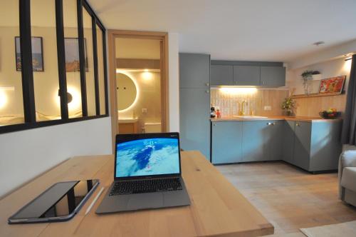 ordenador portátil con mesa de madera en la cocina en MONACO # MENTON - 4 PERSONS - HYPERCENTER - BEACH AND SUN - PRIVATE PARKING - CLIM - FULL RENOVATED - FAST WIFi, en Menton