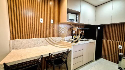 a kitchen with a counter with a sink and a microwave at Coruja Imob - Flat Crystal Place in Goiânia