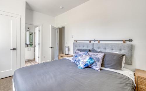 a bedroom with a large gray bed with pillows at Harbor Lights 2 Family Fun Retreat Coastal Comfort in Depoe Bay
