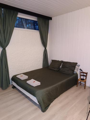 - une chambre avec un lit, une fenêtre et une chaise dans l'établissement Le Bon Séjour, studio à 2 pas du Futuroscope, à Chasseneuil-du-Poitou