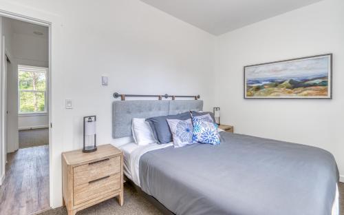 a bedroom with a large bed and a night stand at Harbor Lights 2 Family Fun Retreat Coastal Comfort in Depoe Bay