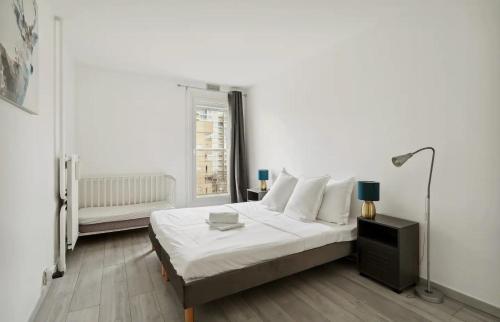 une chambre blanche avec un lit et une fenêtre dans l'établissement le cocon, à Nanterre