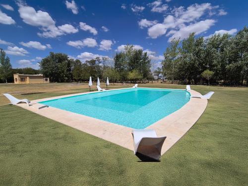 ein Pool auf einem Feld mit Sonnenschirmen in der Unterkunft El Reencanto in Mercedes
