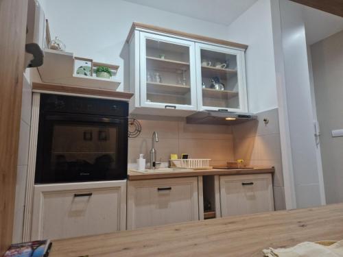 a kitchen with white cabinets and a counter top at Apartman Park in Apatin