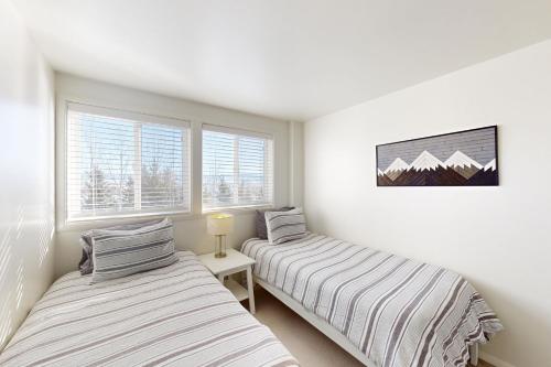 two beds in a room with two windows at Tensleep B11 in Teton Village