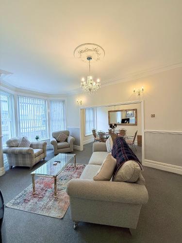 a living room with a couch and a table at Large Luxury Apartment Blackpool in Blackpool