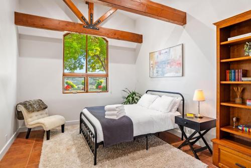 a bedroom with a bed and a chair and a window at Krisyn Vineyards in Templeton