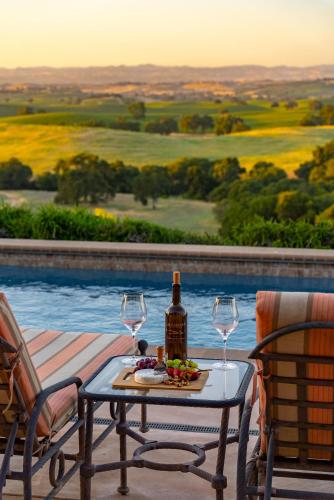 a table with a bottle of wine and two glasses at Krisyn Vineyards in Templeton