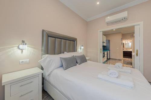 een slaapkamer met een groot wit bed en een spiegel bij ISG Apartments Jose de Velilla Centro Parking in Sevilla