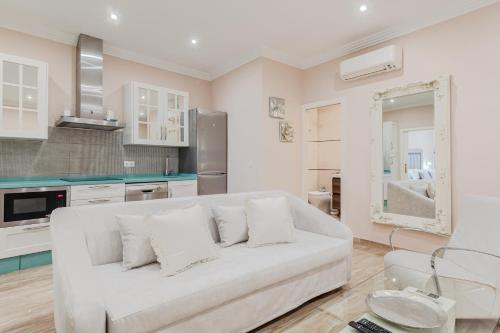 een woonkamer met een witte bank in een keuken bij ISG Apartments Jose de Velilla Centro Parking in Sevilla