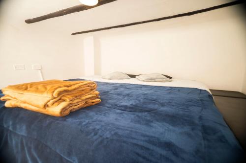 a bed with a blue blanket on top of it at Casa Tsao in Bogotá