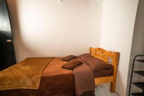 a bedroom with a bed with two pillows on it at Casa Tsao in Bogotá