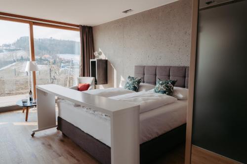 a white bed in a room with a large window at RELAX APARTMENTS An der Lage Hochgraßnitzberg in Spielfeld
