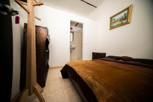a bedroom with a bed and a bathroom at Casa Tsao in Bogotá