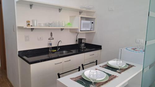 een keuken met een wastafel en een aanrecht met twee borden bij Flat Centro de Curitiba Rua 24 horas in Curitiba