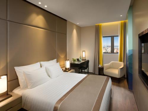 Habitación de hotel con cama grande y escritorio. en Golden Crown Haifa en Haifa