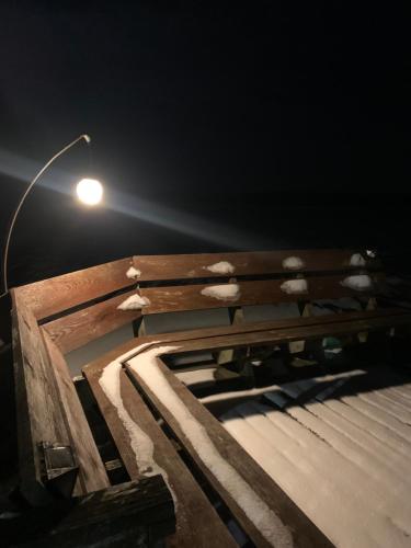 a street light sitting next to a wooden bench at Poilsis ant Virintų ežero kranto in Molėtai
