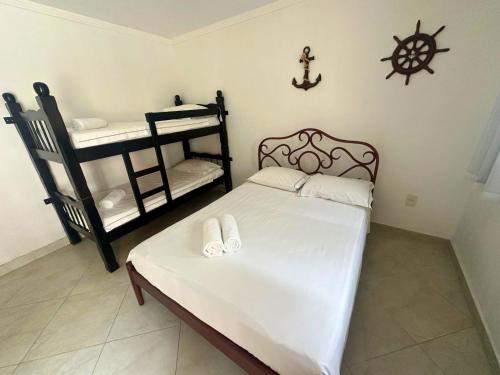 a bedroom with a bed and two bunk beds at Pousada Acqua Azul in Bertioga