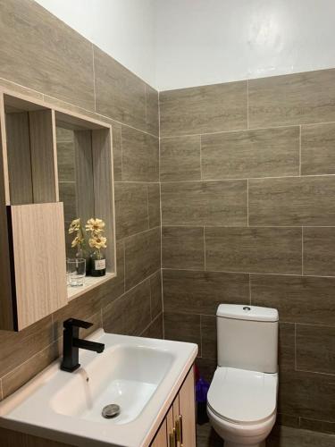 a bathroom with a white sink and a toilet at STUDIO East Legon, Adjiringanor in Ogbojo