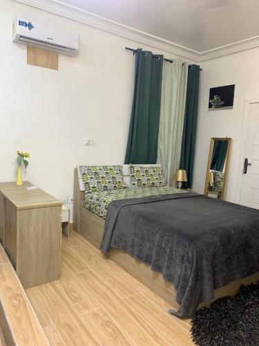 a bedroom with a bed and a dresser in it at STUDIO East Legon, Adjiringanor in Ogbojo