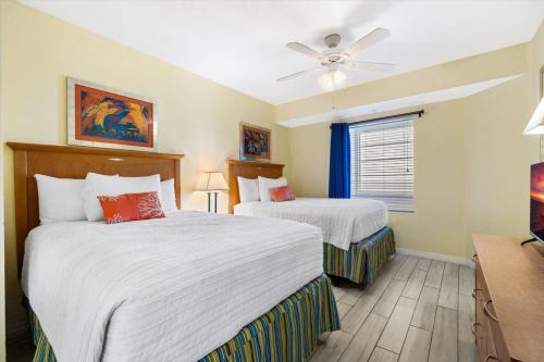a bedroom with two beds and a ceiling fan at Serene Oceanfront Getaway 1BR with Private Balcony at Wyndham Oceanwalk in Daytona Beach