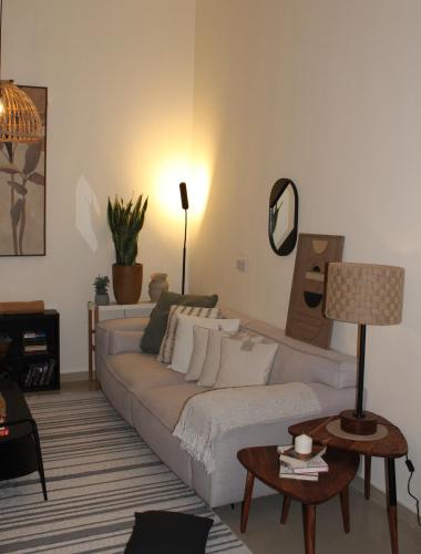 a living room with a white couch and a table at Boho Style Cozy 1 BHK Apartment in Abu Dhabi