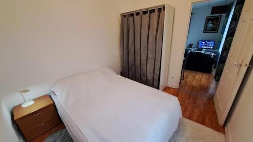 une chambre avec un lit et une porte donnant sur une pièce dans l'établissement Cozy apartment near Paris, à Domont