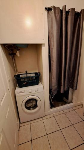 une petite cuisine avec un lave-linge et une fenêtre dans l'établissement Cozy apartment near Paris, à Domont