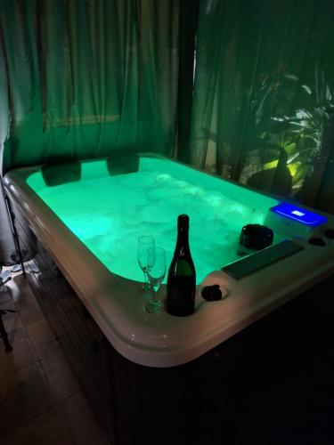una vasca da bagno con una bottiglia di vino e un bicchiere di Loft con SPA exterior climatizado Villa IRI a Pineda de Mar