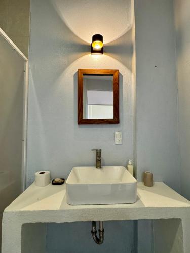 a bathroom with a white sink and a mirror at Casa Zianda - Departamentos en Puerto Escondido in Brisas de Zicatela