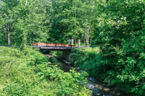 un ponte sopra un fiume con una panchina sopra di Trail Head by Stony Brook Cabins a Gatlinburg
