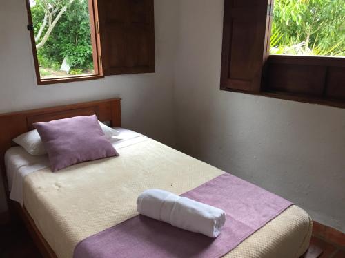 a bed with a pillow and a towel on it at Casa campo Casa 4 in Barichara