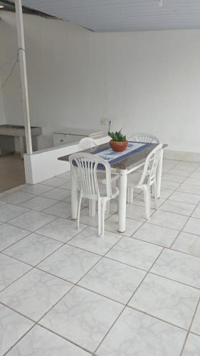 a white table and chairs with a potted plant on it at Casa Aconchegante na praça 14 in Manaus