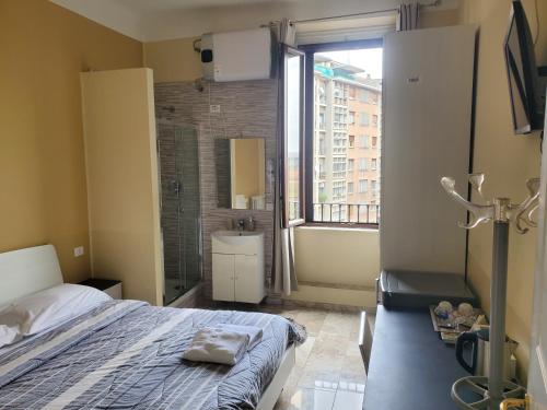 sypialnia z łóżkiem oraz łazienka z oknem w obiekcie Hotel Emmy w Mediolanie