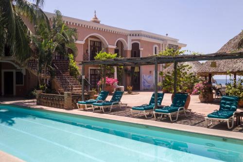 a group of chairs and a swimming pool in front of a house at Hotel Santa Fe in Puerto Escondido