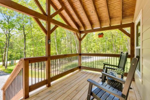 a porch with two chairs and a wooden roof at Fern Cottage in Menlo GA in Rising Fawn