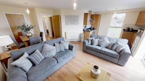a living room with two couches and a table at Lovely Furnished Apartment 2 in Carlisle